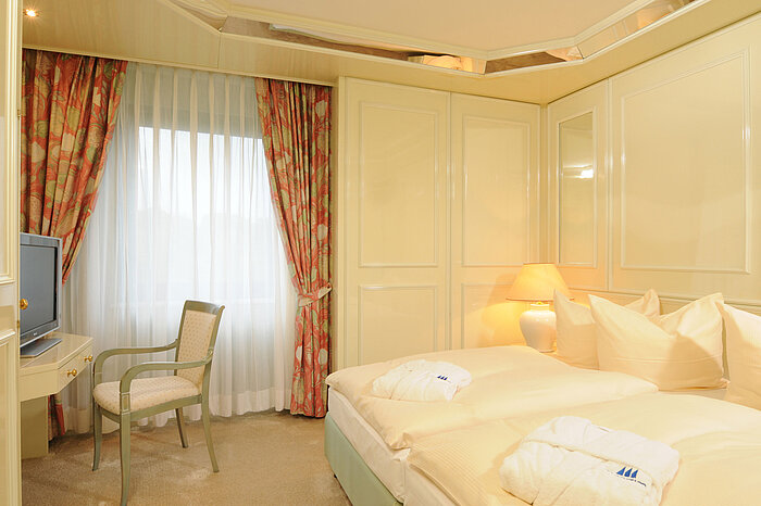 Helle Suite im Maritim Hotel Bremen mit elegantem Bett, Sitzbereich und sanfter Beleuchtung.
