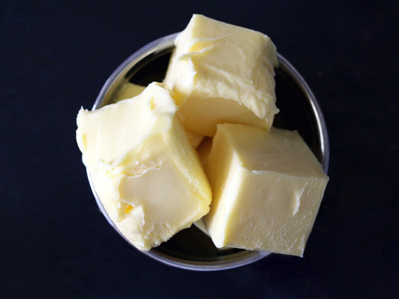Portionsstücke Butter in einer kleinen Schale am Frühstücksbuffet.