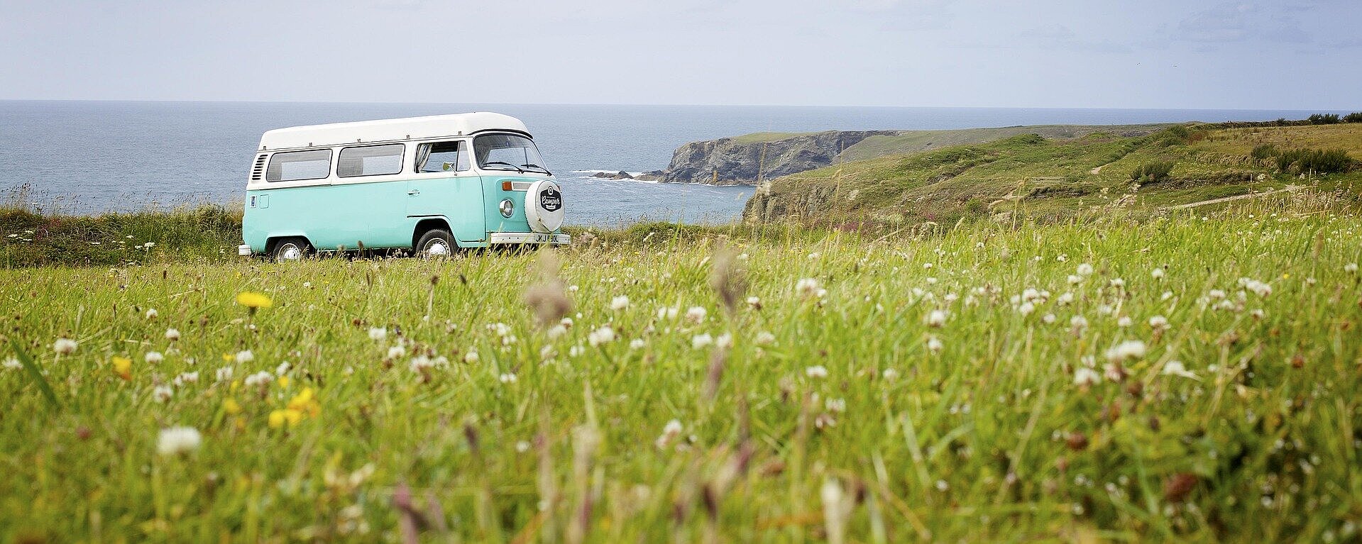 © vw-bus-pixabay.com.jpg Retro-VW-Bus auf einer Wiese mit Blick auf das Meer und die Küste – perfekter Start ins nächste Abenteuer