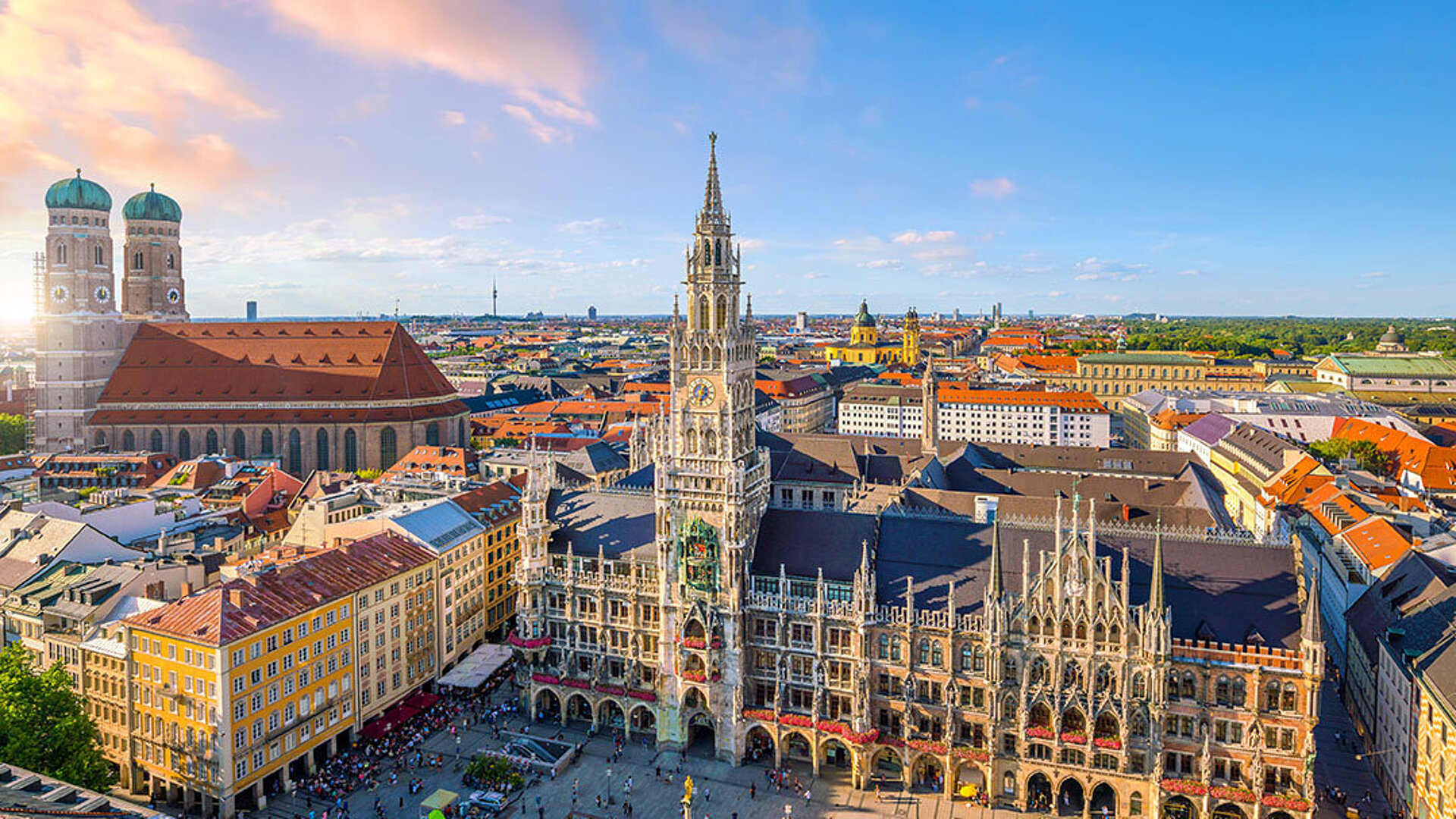 Blick auf den Marienplatz in München mit dem Neuen Rathaus und der Frauenkirche an einem sonnigen Tag