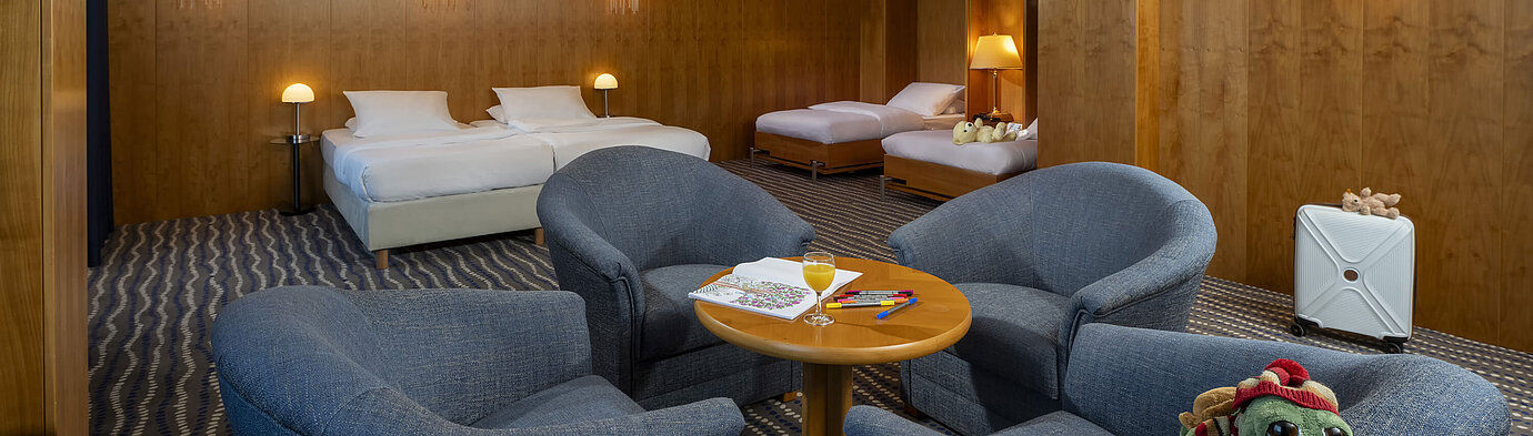 Geräumiges Superior-Familienzimmer im Maritim Hotel Magdeburg mit zwei Doppelbetten, Sitzecke und kindgerechten Details.