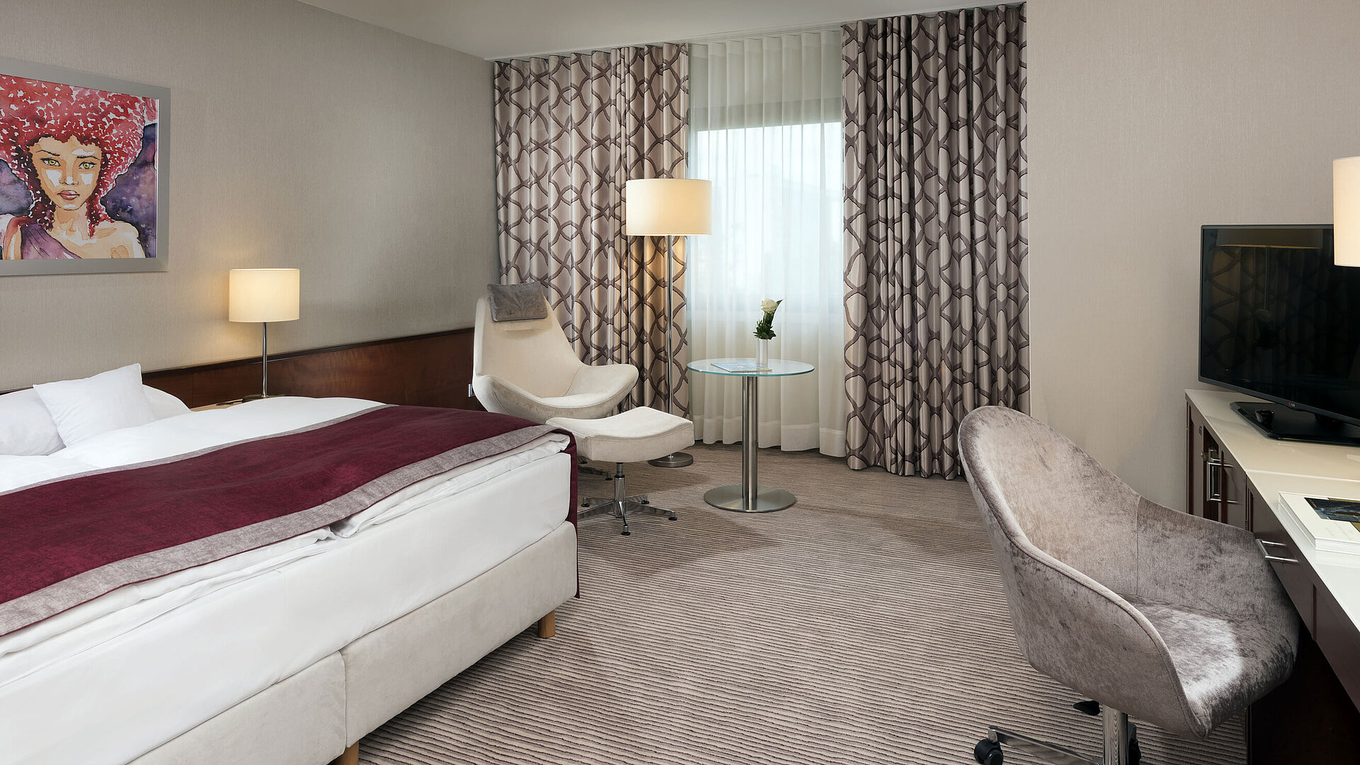 Comfort Zimmer im Maritim Hotel Bonn mit gemütlichem Bett, Sesseln, Schreibtisch und modernen Vorhängen.