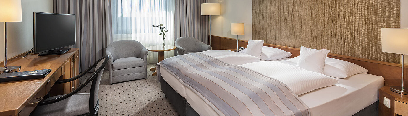 Modernes Classic Doppelzimmer mit gemütlichem Doppelbett, Sitzbereich und Schreibtisch im Maritim Hotel Hannover.