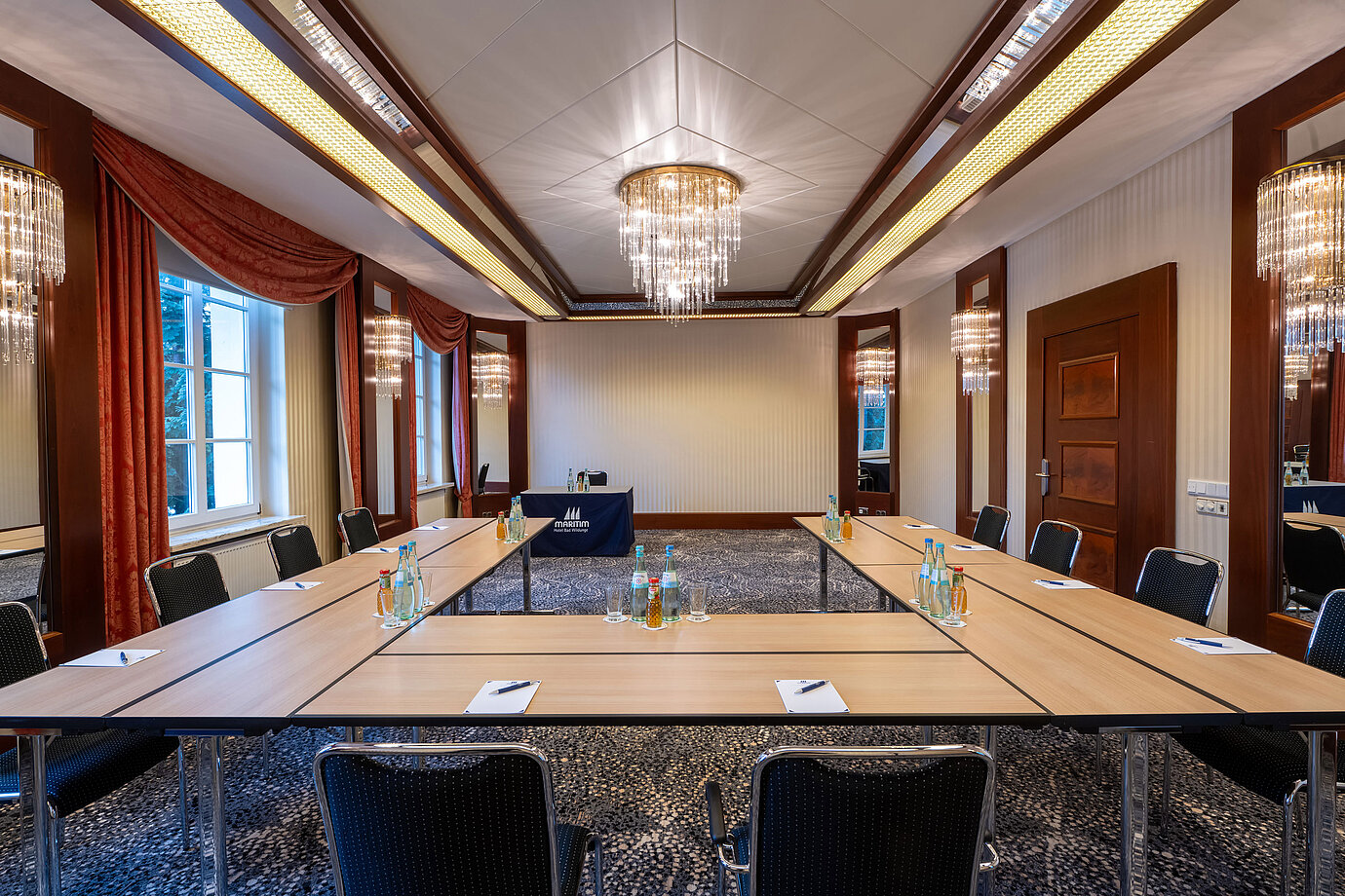 Stilvoller Tagungsraum im Maritim Hotel mit U-förmig angeordneten Tischen und Präsentationsfläche.