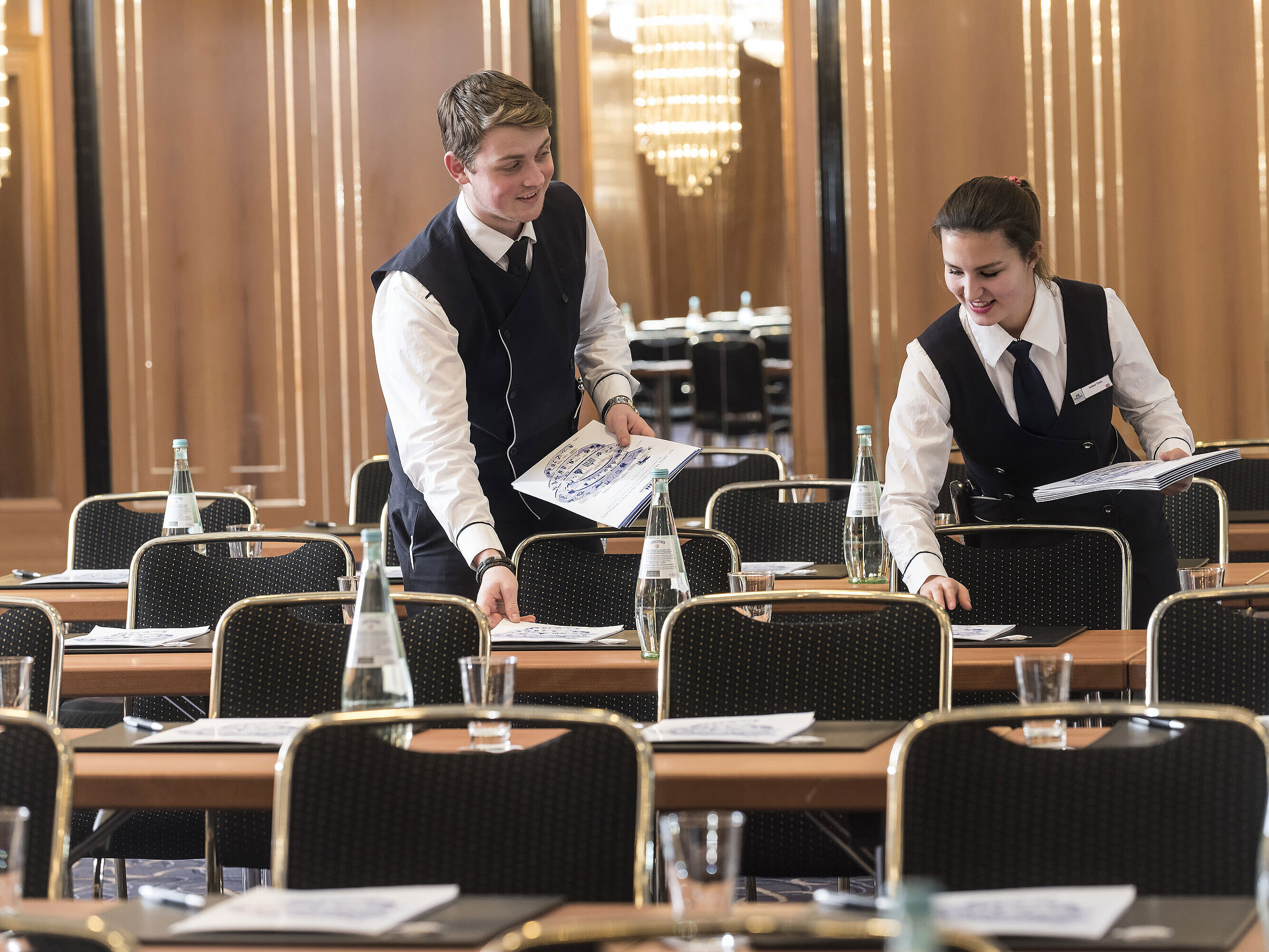 Zwei Mitarbeitende legen Konferenzunterlagen auf die Tische im Maritim Hotel Stuttgart