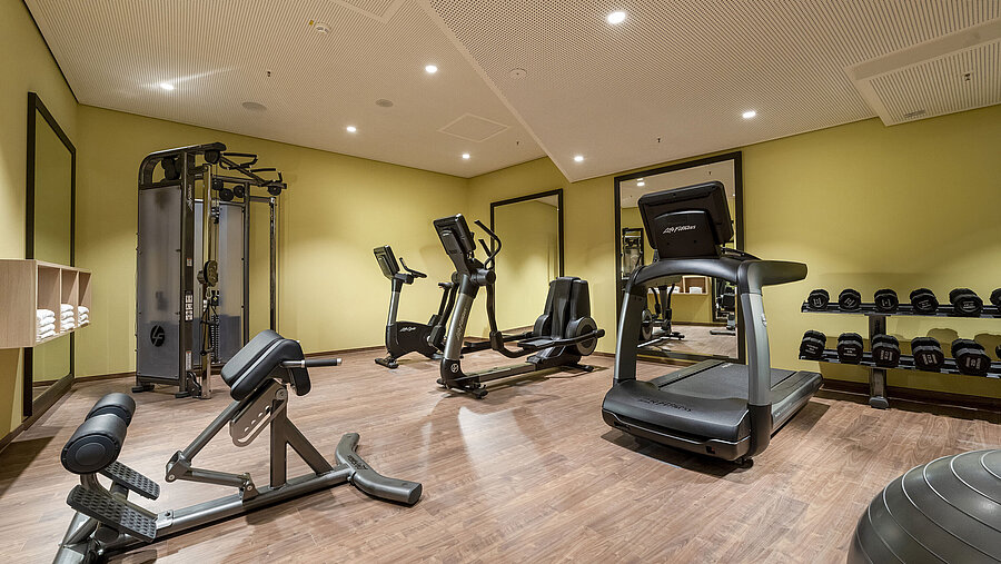 Modern ausgestatteter Fitnessraum im Maritim Hotel Ingolstadt mit Laufband, Hanteln und Trainingsgeräten.