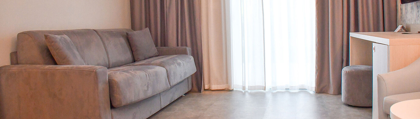 Komfortables Schlafsofa im lichtdurchfluteten Zimmer des Maritim Resort Calabria