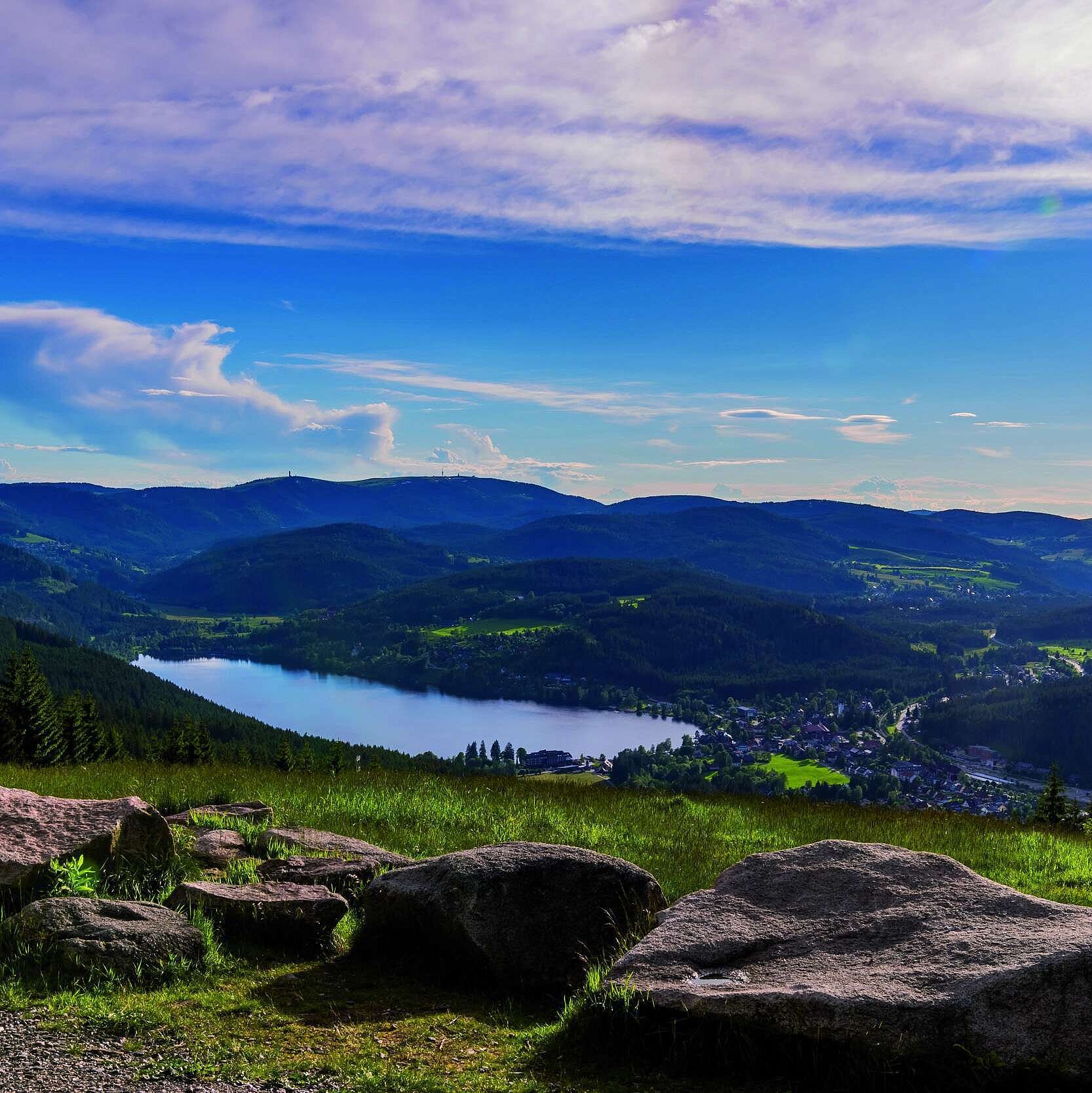 Weitblick auf den Titisee und den Schwarzwald vom Hochfirst mit Wiesen, Felsen und bewaldeten Hügeln