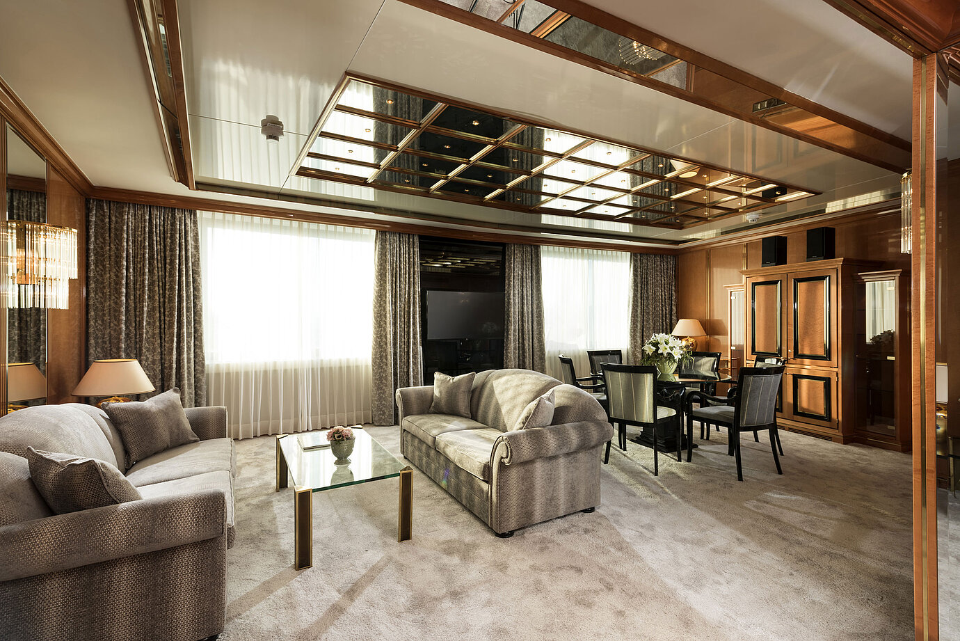 Heller Wohnbereich der Suite im Maritim Hotel Ulm mit zwei Sofas, Glastisch und Esstisch