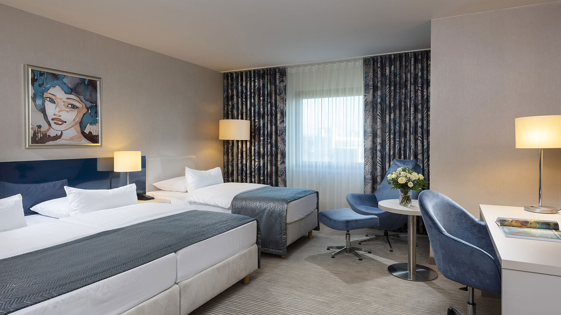 Familienzimmer im Maritim Hotel Bonn mit einem Doppelbett, Einzelbett, Schreibtisch, gemütlicher Sitzecke und modernem Design.