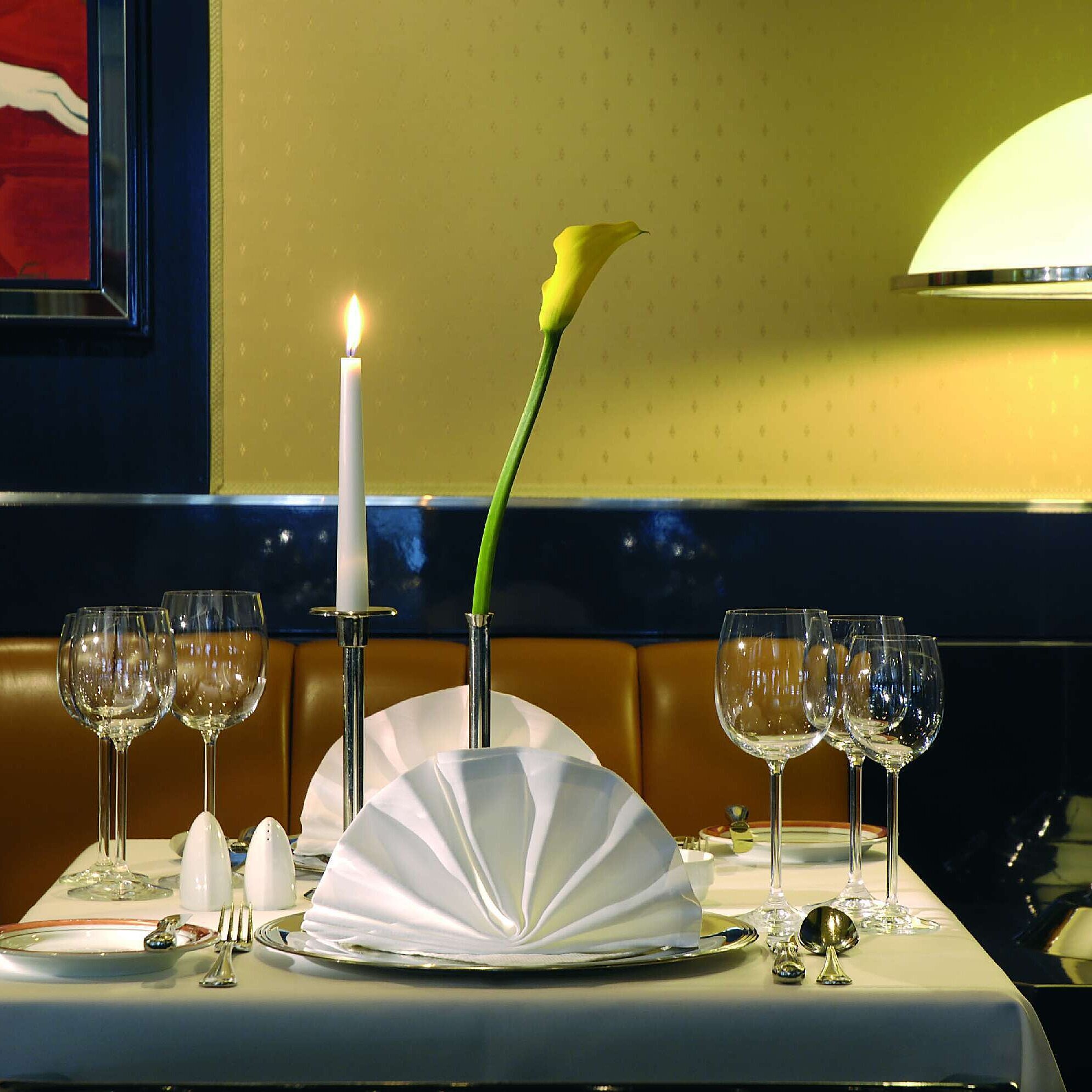 Festlich gedeckter Tisch mit Kerze und Weingläsern im Restaurant des Maritim Hotel Magdeburg