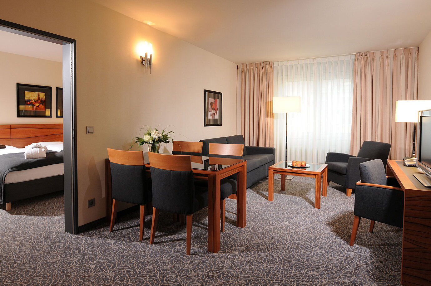 Großzügige Suite mit Wohnzimmer, Esstisch und separatem Schlafzimmer im Maritim Hotel München