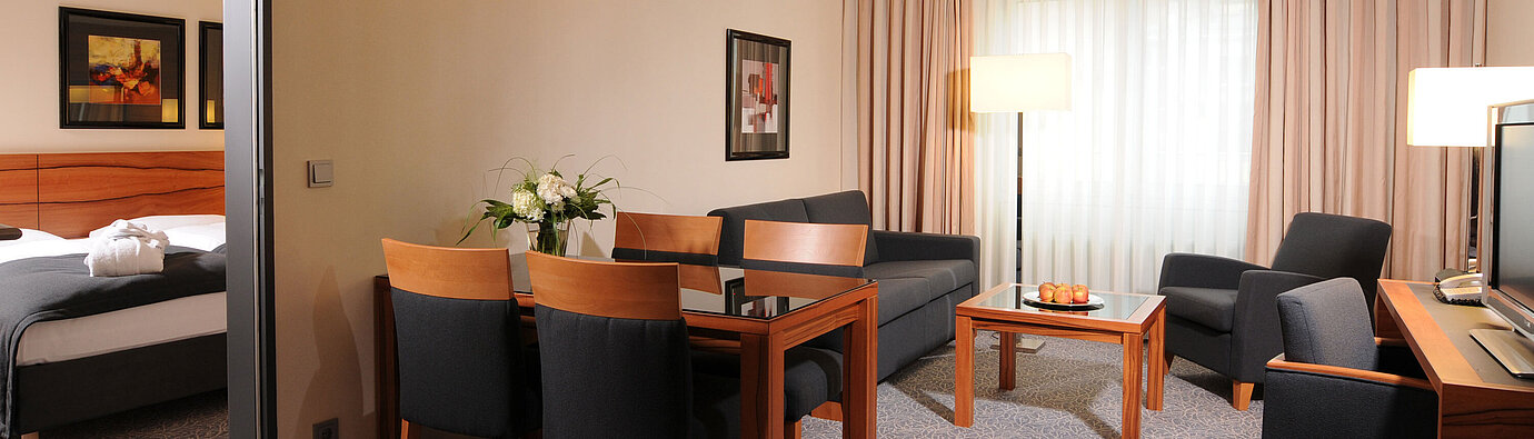 Großzügige Suite mit Wohnzimmer, Esstisch und separatem Schlafzimmer im Maritim Hotel München