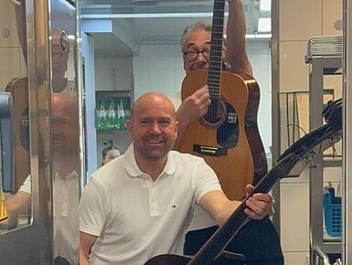Musiker mit Kontrabass und Gitarre in der Hotelküche bei einer Küchenparty