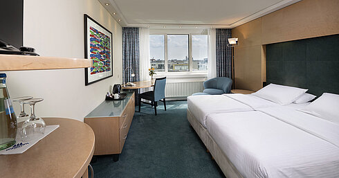Comfort Zimmer mit Doppelbett, Schreibtisch und gemütlicher Sitzecke im Maritim proArte Hotel Berlin