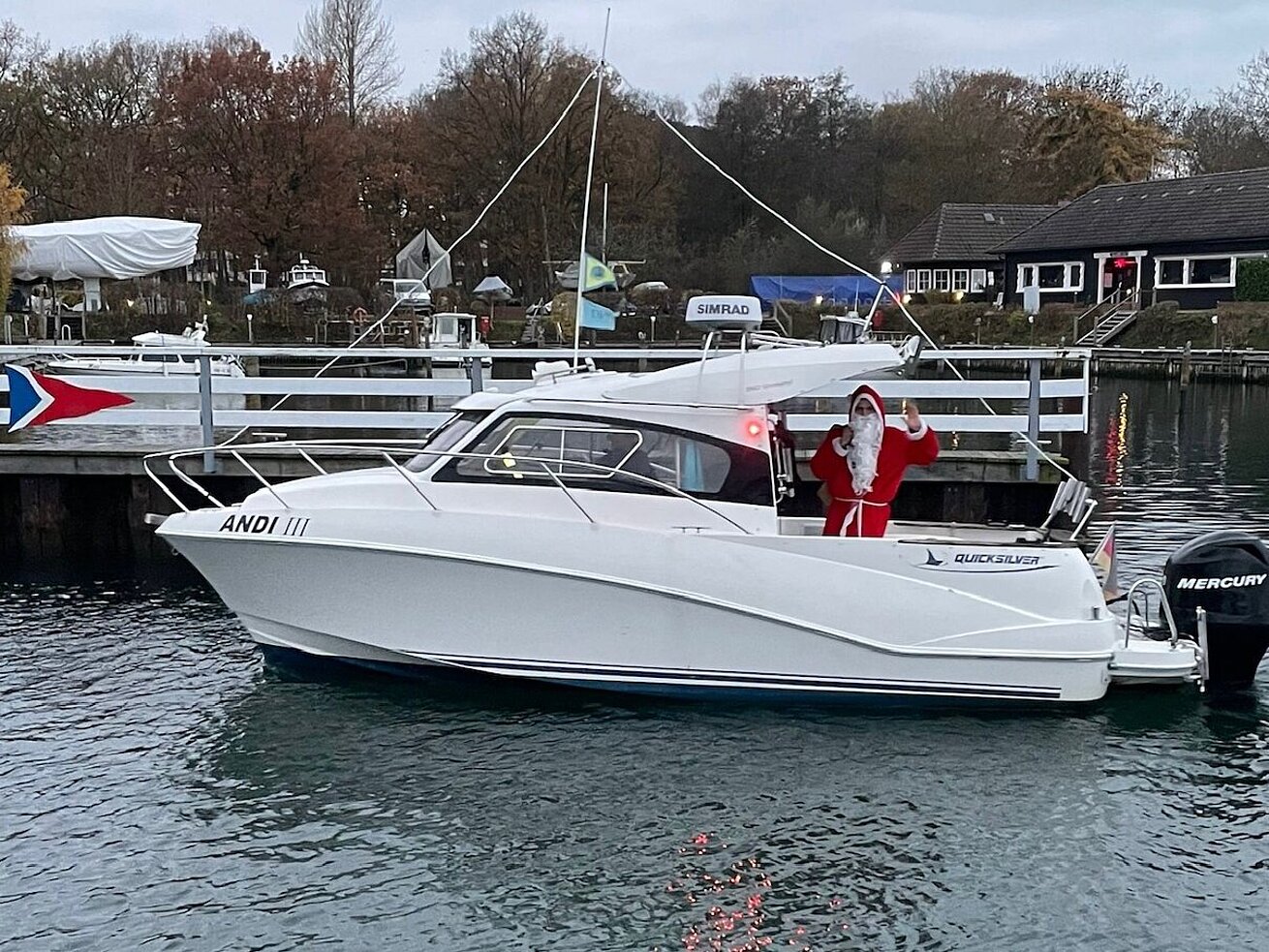 Nikolaus auf einem Motorboot im Hafen, winterliche Szene mit weihnachtlicher Stimmung