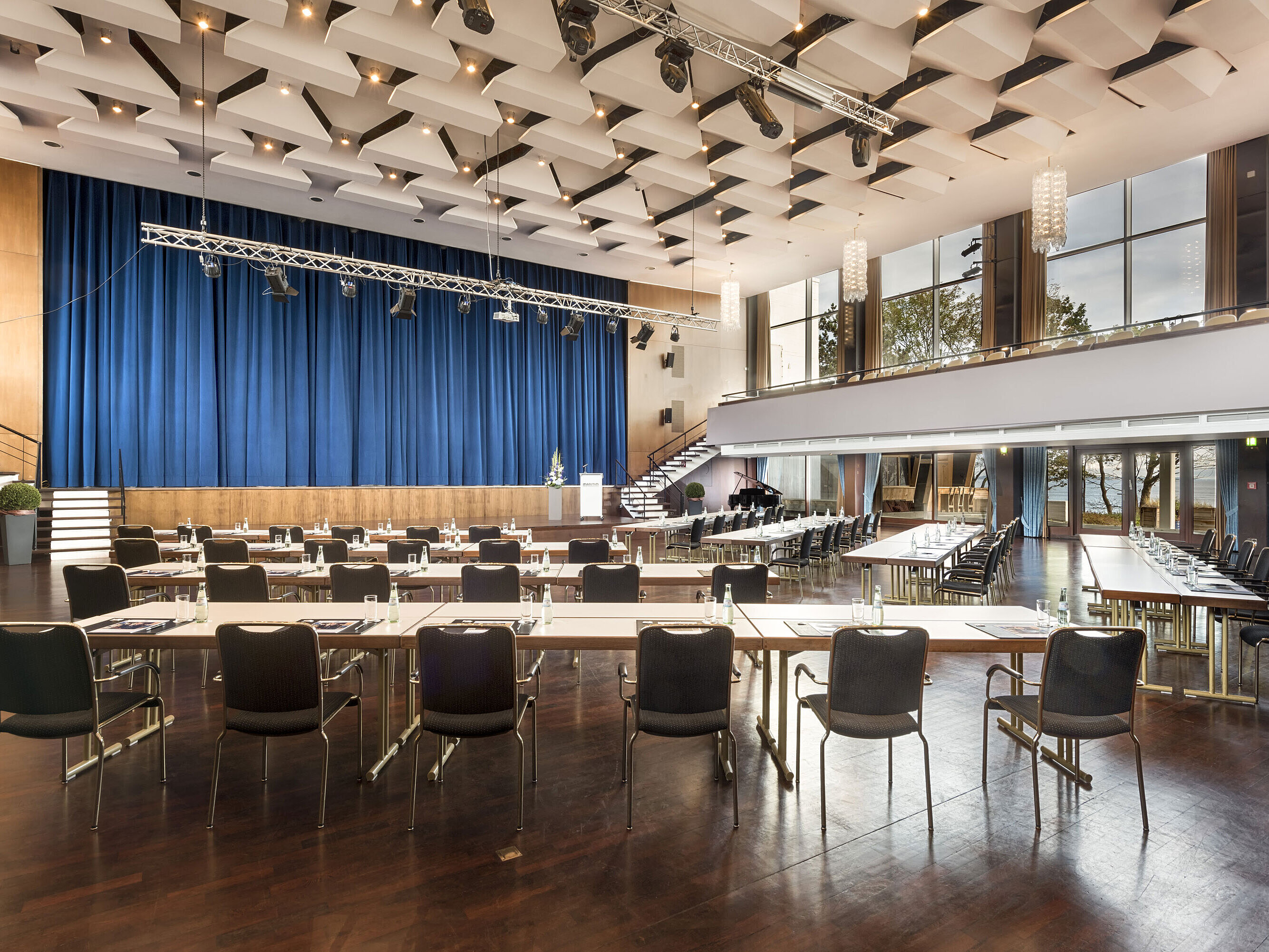 Großer Saal „Maritim“ im Maritim Seehotel Timmendorfer Strand mit Bühne, blauen Vorhängen und Bestuhlung für Tagungen.