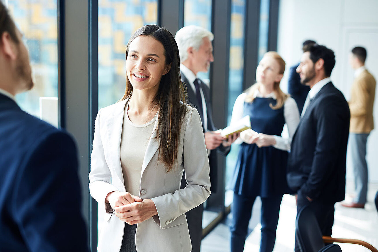 © pressmaster – AdobeStock.com Business-Netzwerken während Konferenzpause im modernen Tagungsbereich