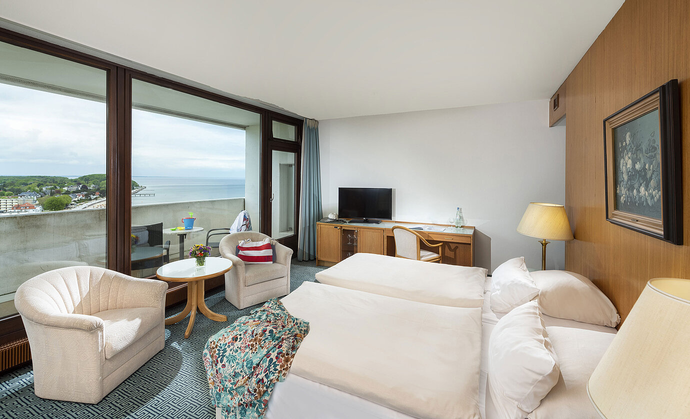 Komfortables Zimmer mit zwei Sesseln und Balkon mit Meerblick im Maritim Hotel Travemünde