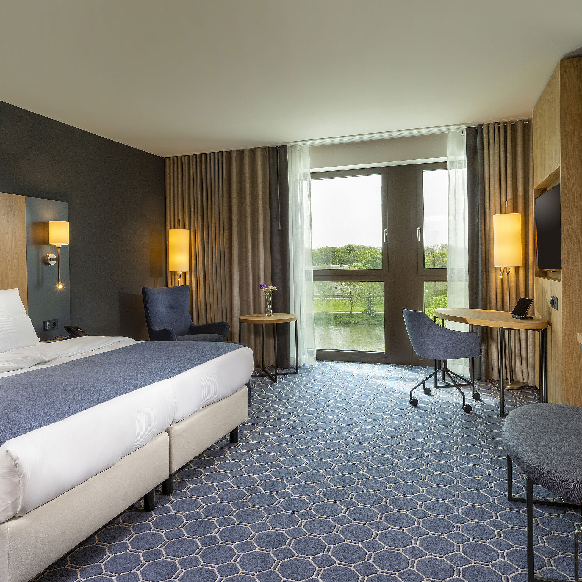Superior Zimmer Geräumiges Doppelzimmer im Maritim Hotel Ingolstadt mit großem Bett, Schreibtisch und Blick auf den Fluss.