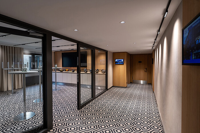 Moderner Kaffeepausen-Bereich mit Stehtischen, Kaffeemaschine und stilvollem Ambiente für Meetings und Tagungen.