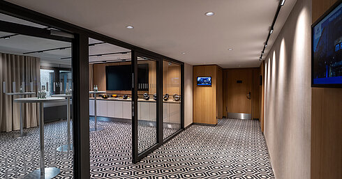 Moderner Kaffeepausen-Bereich mit Stehtischen, Kaffeemaschine und stilvollem Ambiente für Meetings und Tagungen.