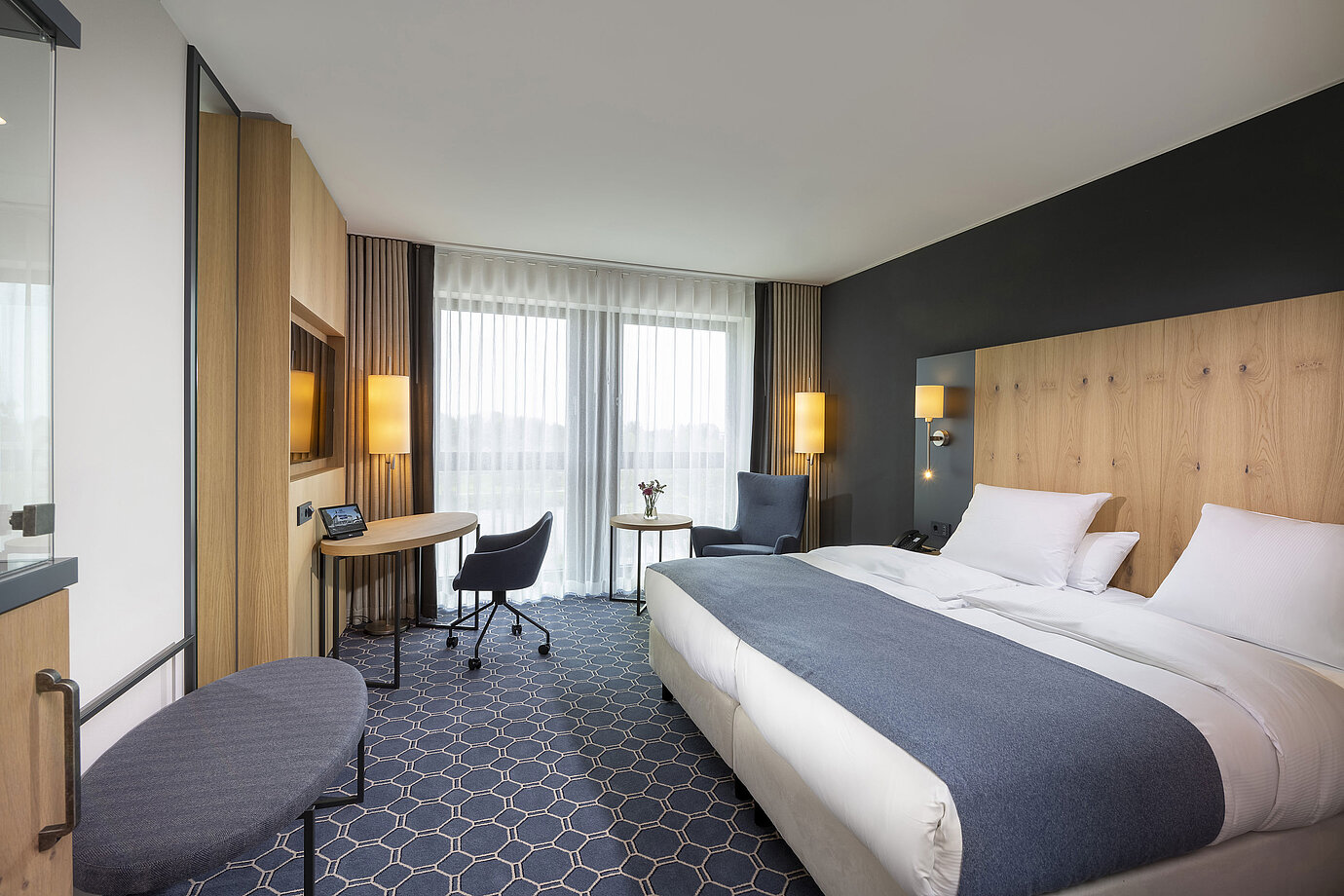 Geräumiges Doppelzimmer im Maritim Hotel Ingolstadt mit Schreibtisch, Sitzbereich und Balkon.