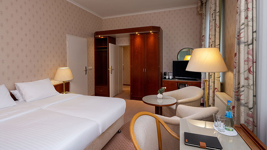 Comfort Familienzimmer mit Doppelbett, Sitzecke, Schreibtisch, TV und heller, gemütlicher Einrichtung.