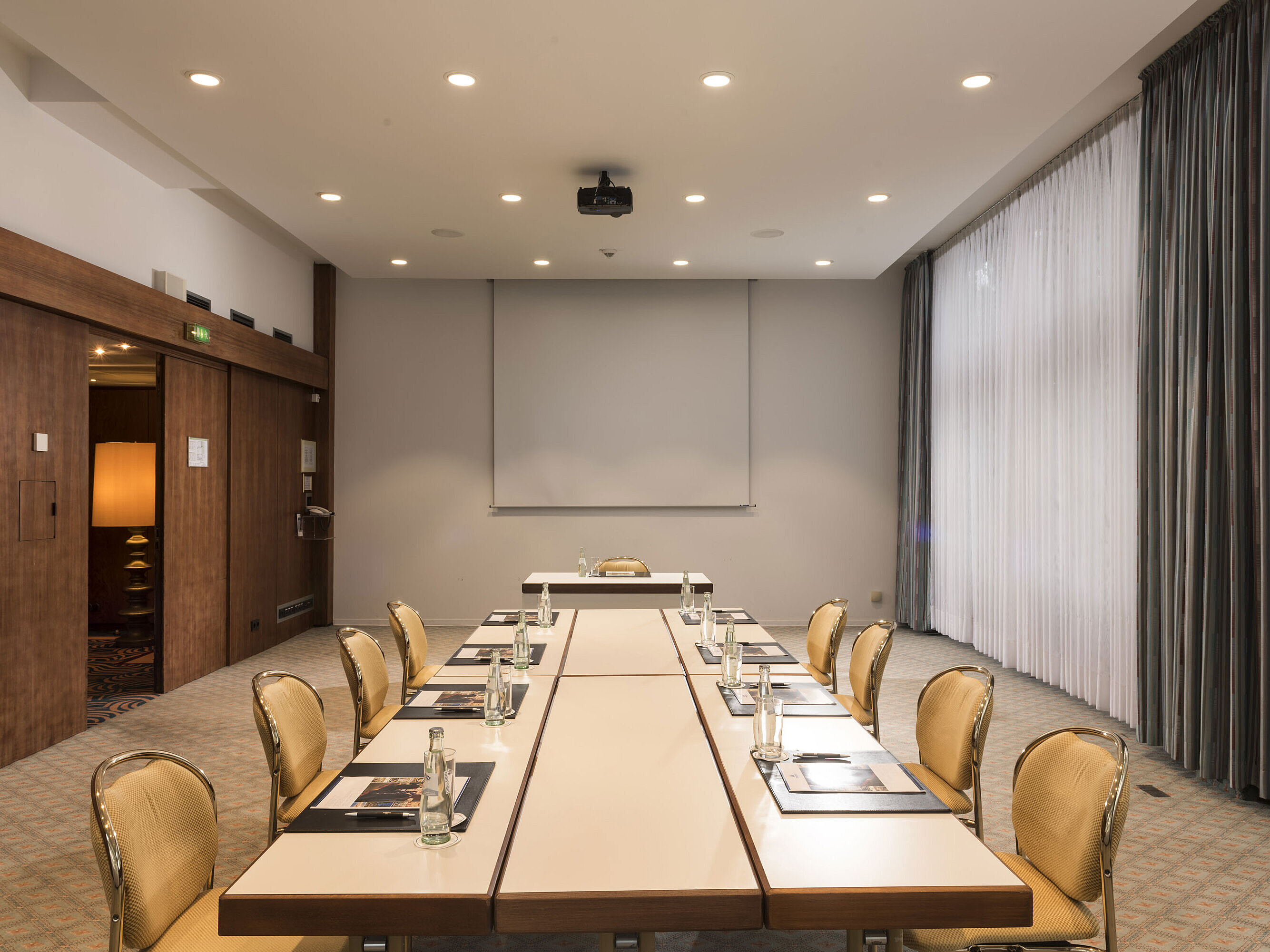 Konferenzraum „Salon Bonn“ im Maritim Seehotel Timmendorfer Strand mit Besprechungstisch,Tageslicht und Präsentationsleinwand