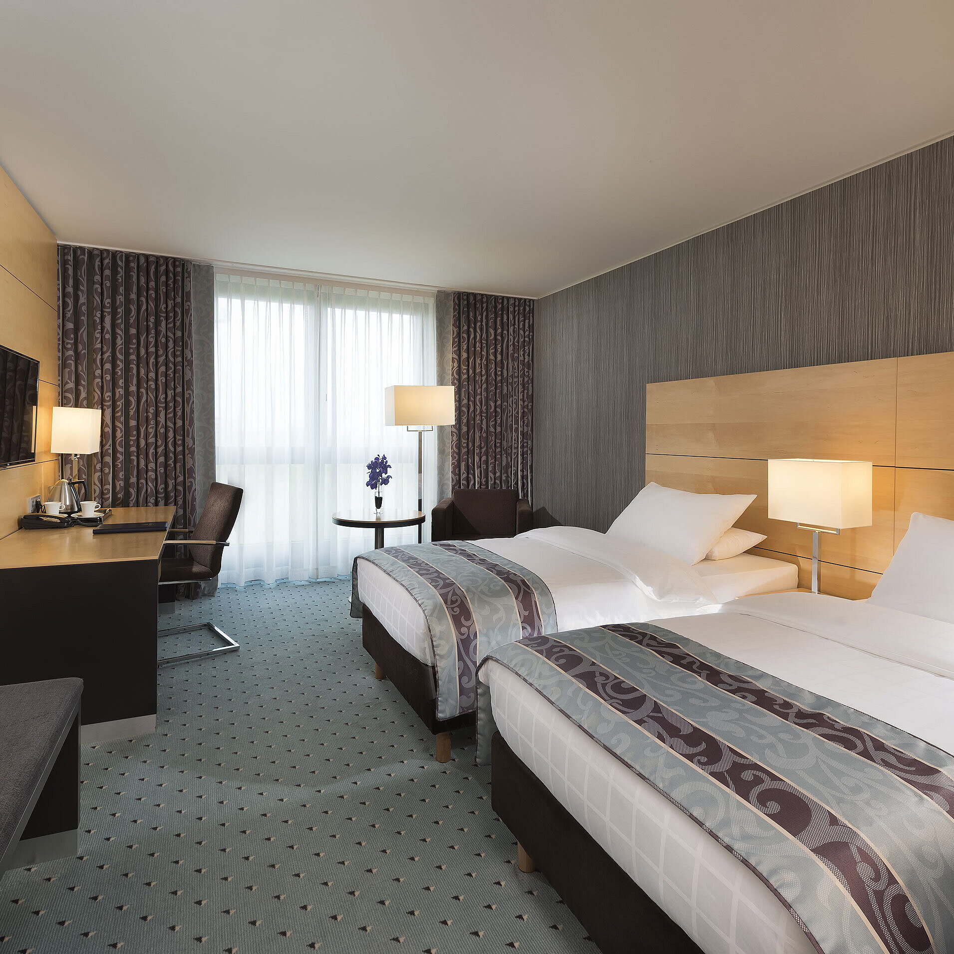 Modernes Classic Twin Zimmer im Maritim Hotel Düsseldorf mit zwei Einzelbetten, Schreibtisch und bodentiefem Fenster.