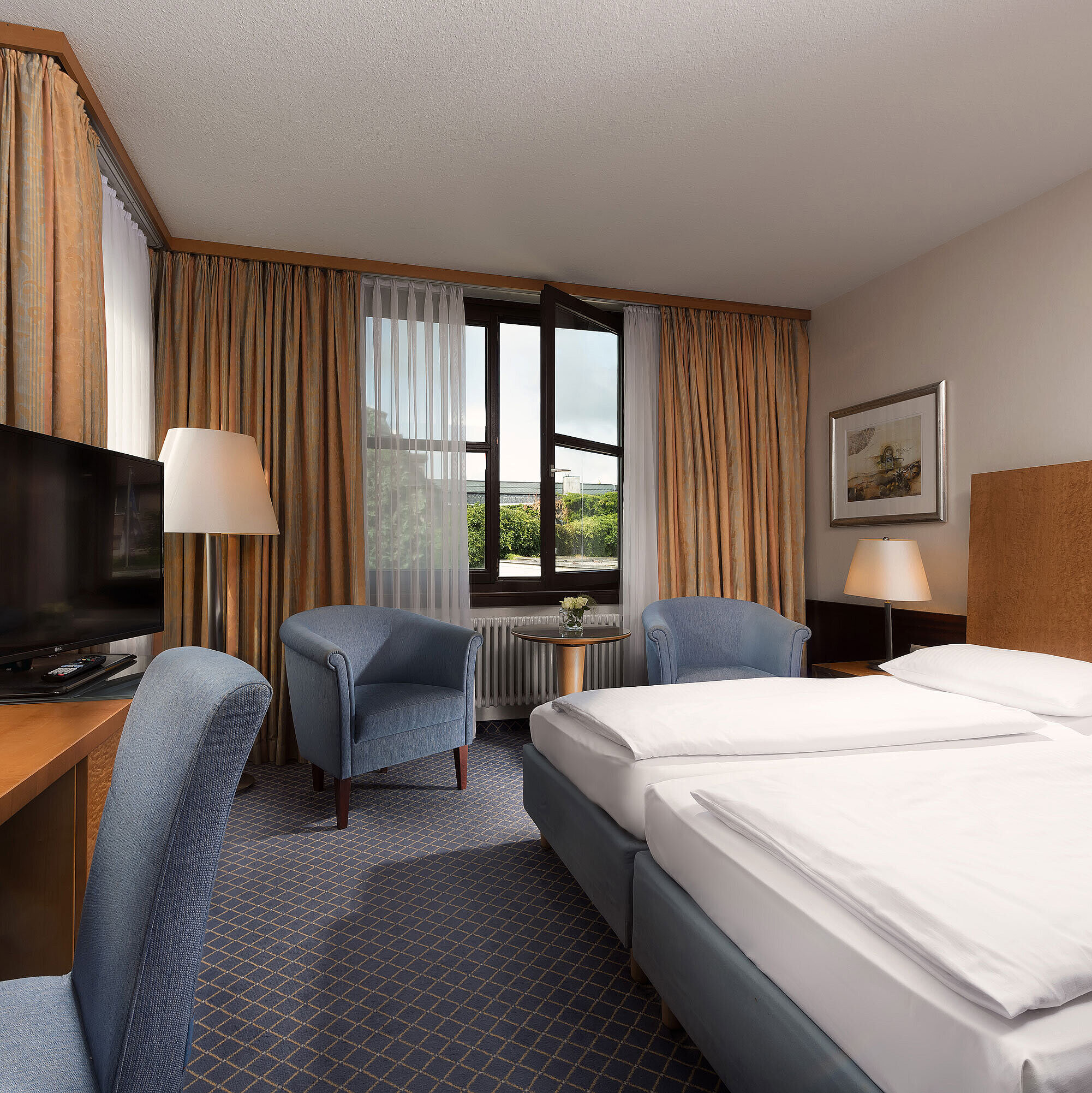 Classic Zimmer Classic Zimmer im Maritim Hotel Fulda mit gemütlichem Doppelbett, Schreibtisch, Sitzbereich und großem Fenster.