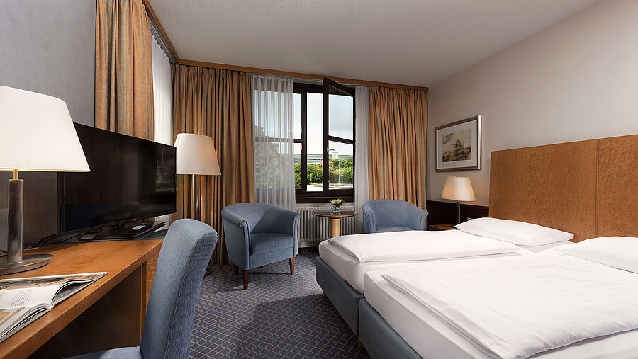 Classic Zimmer im Maritim Hotel Fulda mit gemütlichem Doppelbett, Schreibtisch, Sitzbereich und großem Fenster.