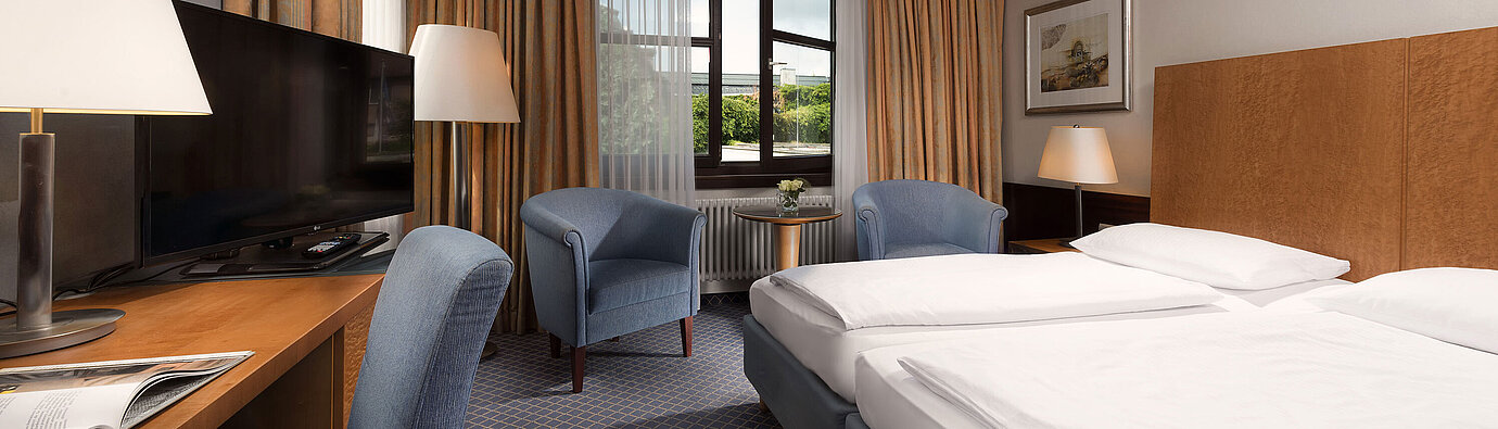 Classic Zimmer im Maritim Hotel Fulda mit gemütlichem Doppelbett, Schreibtisch, Sitzbereich und großem Fenster.