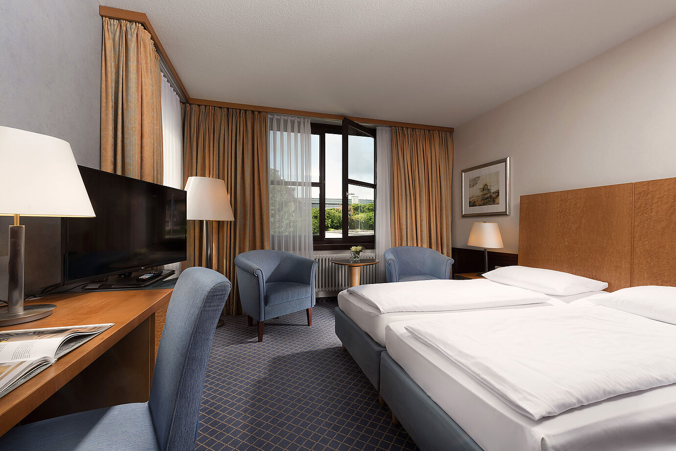 Classic Zimmer im Maritim Hotel Fulda mit gemütlichem Doppelbett, Schreibtisch, Sitzbereich und großem Fenster.