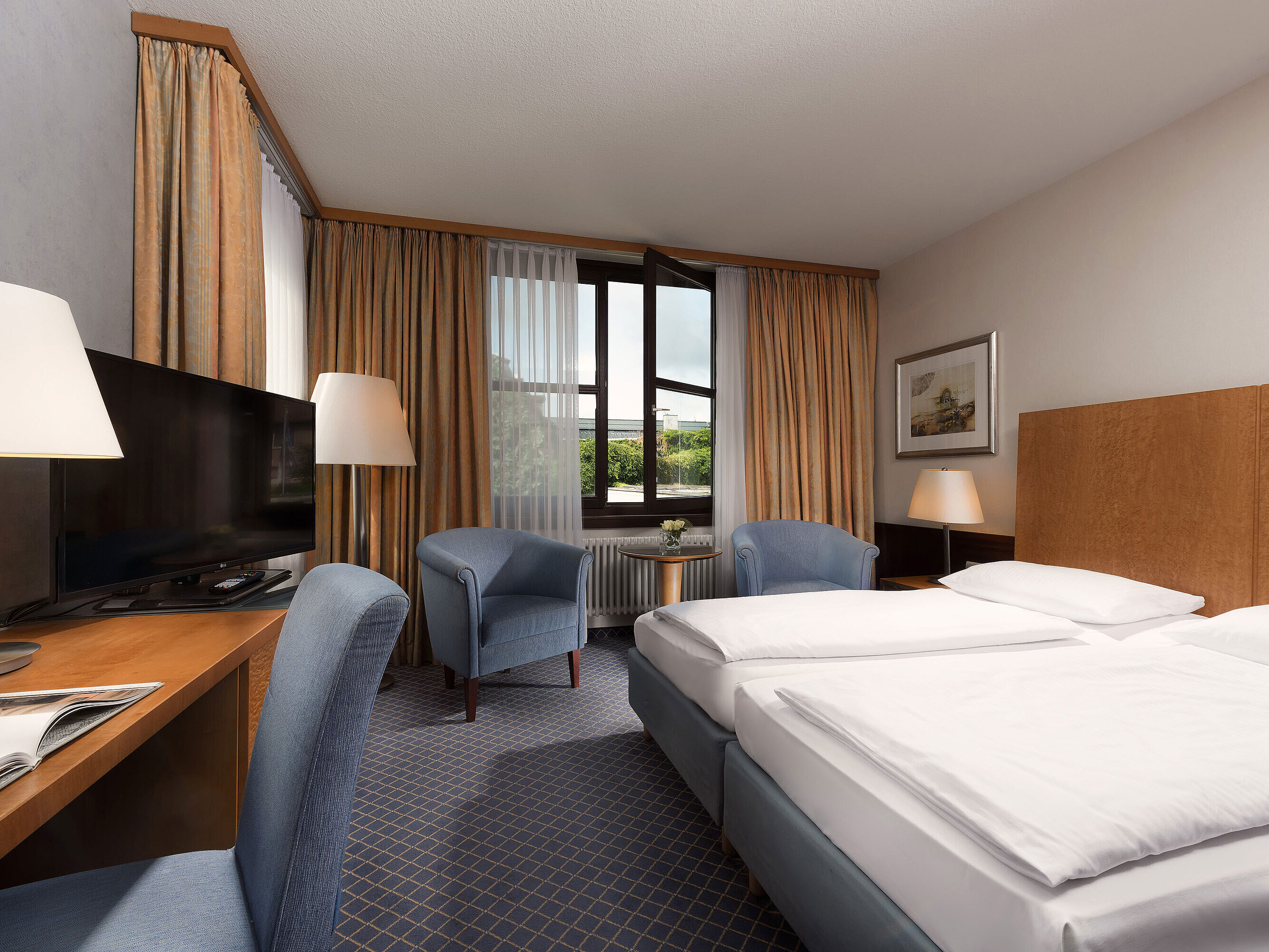 Classic Zimmer im Maritim Hotel Fulda mit gemütlichem Doppelbett, Schreibtisch, Sitzbereich und großem Fenster.