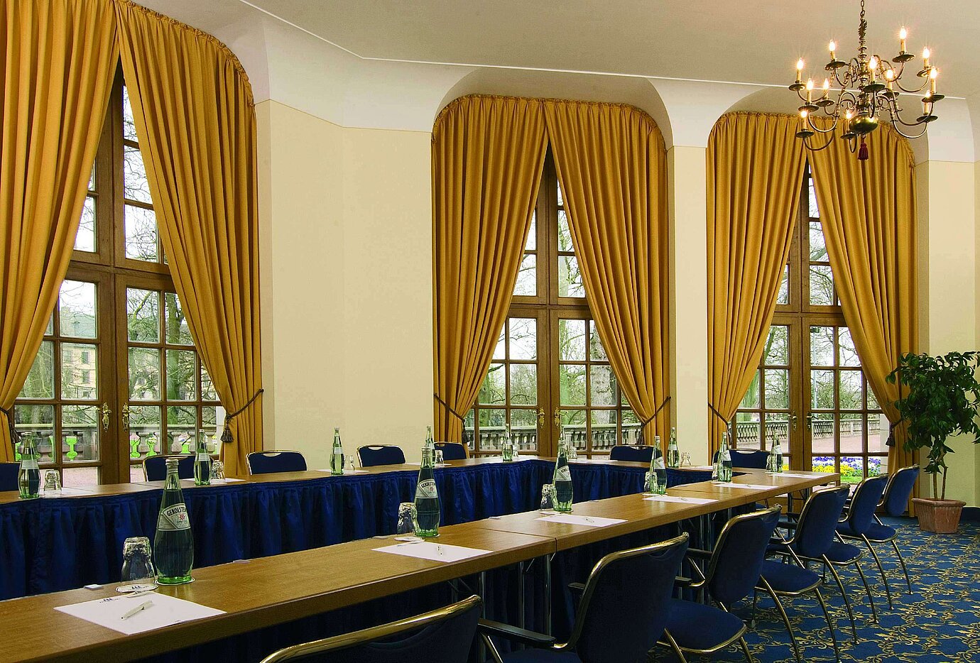 Stilvoller Tagungsraum mit großen Fenstern, goldenen Vorhängen und Kronleuchter im Maritim Hotel Fulda.