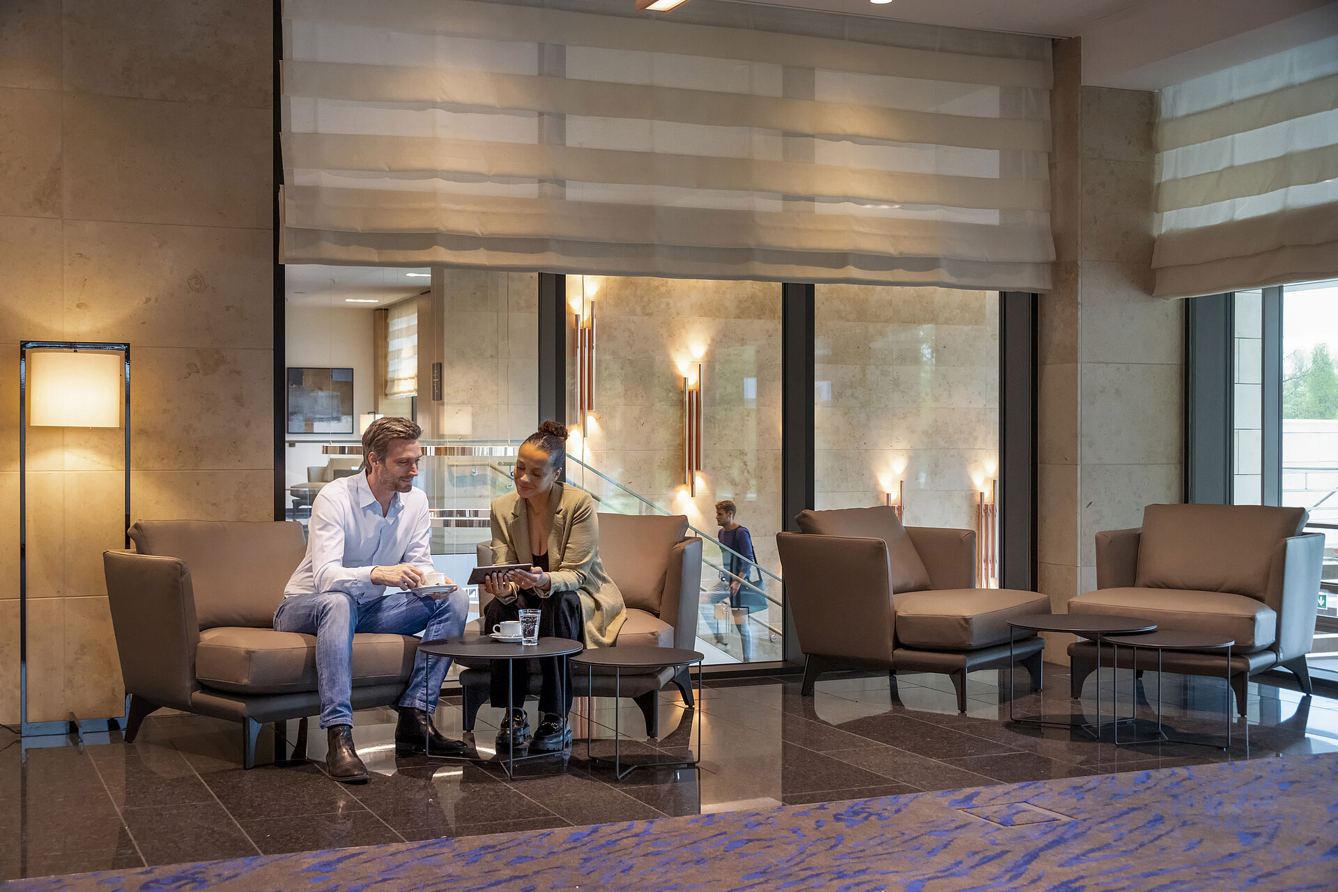 Lobby Ein Mann und eine Frau sitzen in der Lobby des Maritim Hotel Ingolstadt und unterhalten sich bei Kaffee.