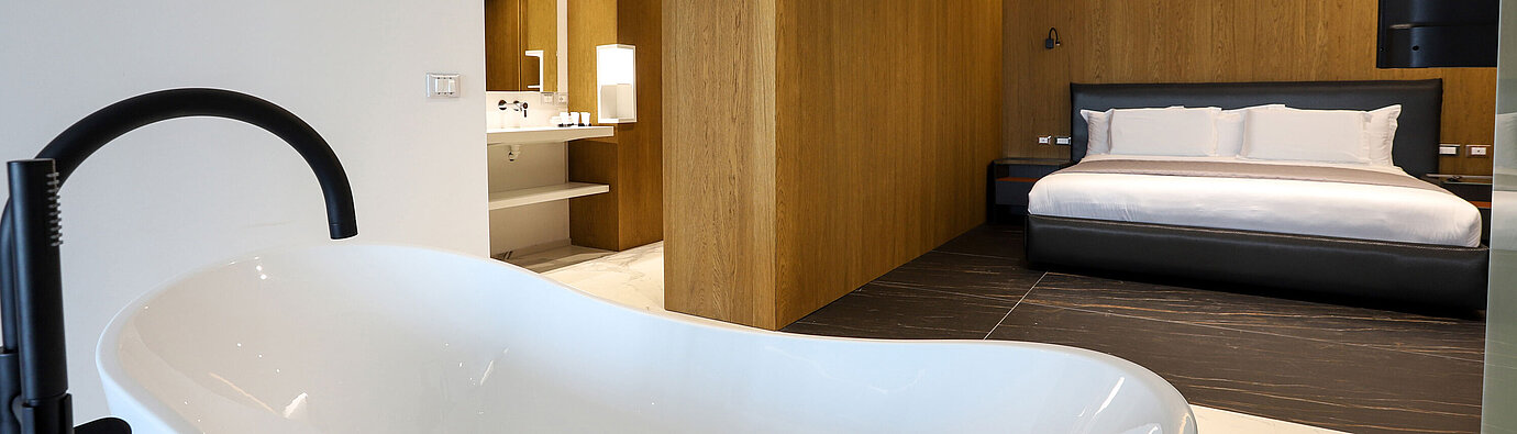 Luxuriöse Suite im Maritim Resort Marina Bay mit freistehender Badewanne und modernem Schlafzimmer