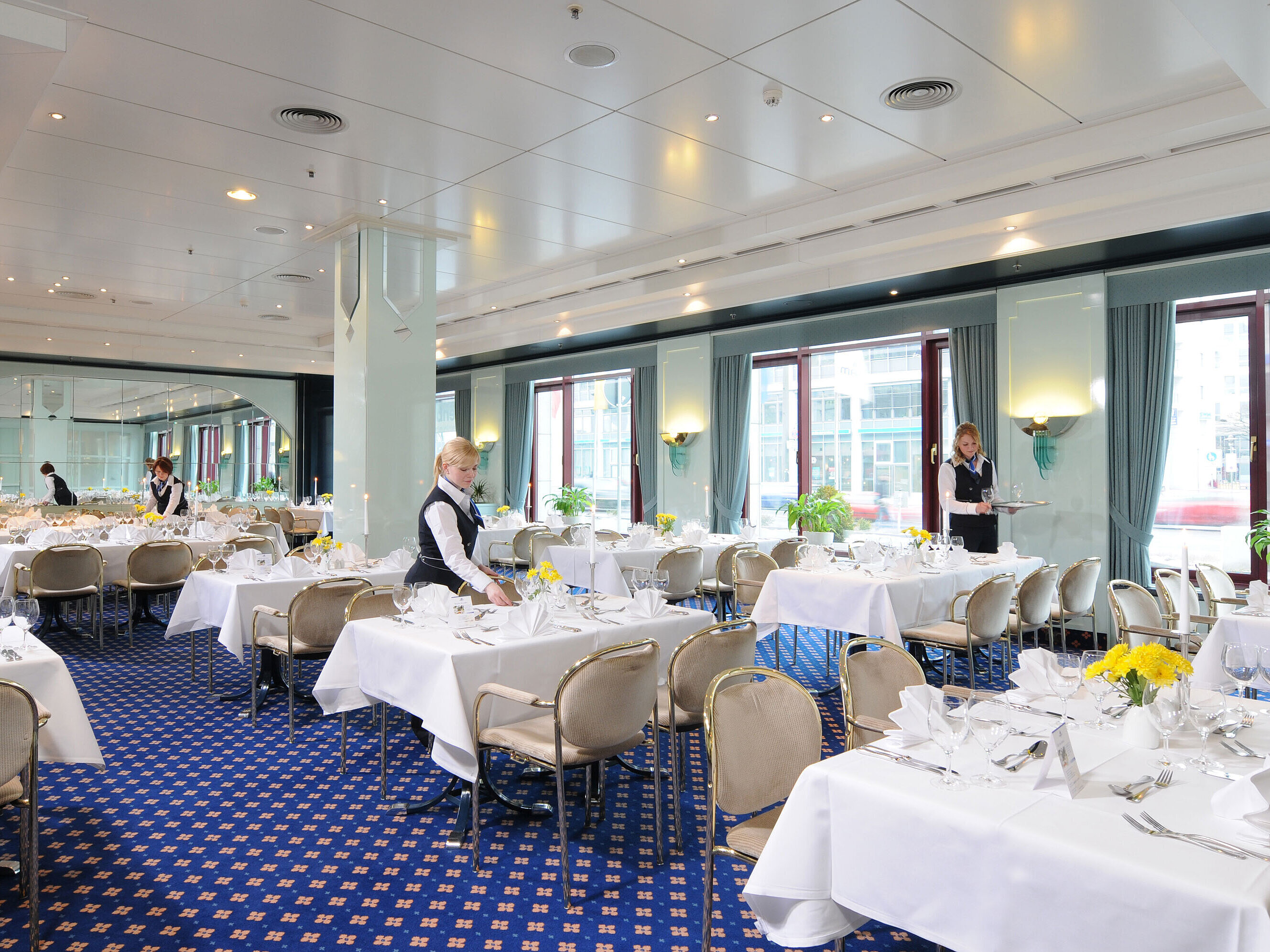 Tagungsraum Salon Bonn im Maritim Hotel Magdeburg mit weiß gedeckten Tischen, eleganter Dekoration und freundlichem Servicepersonal.