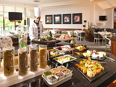 Frühstücksbuffet im Maritim Hotel Bad Homburg mit frischen Speisen, Cerealien und einem freundlichen Koch