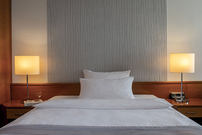 Modernes Superior Zimmer mit stilvollem Bett, Nachttischen und sanfter Beleuchtung im Maritim Hotel Hannover.