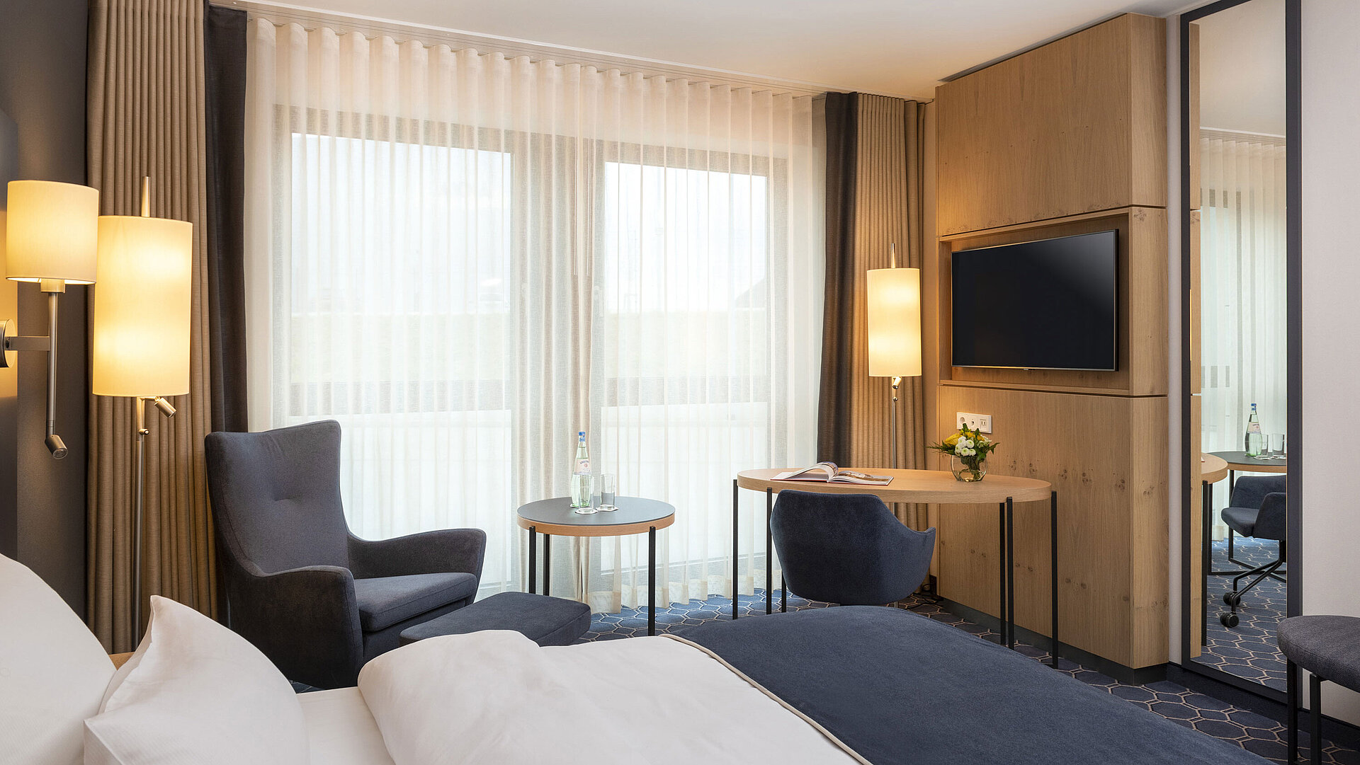 Zimmer Helles Zimmer mit Schreibtisch, TV und gemütlicher Sitzecke im Maritim Hotel Ingolstadt.