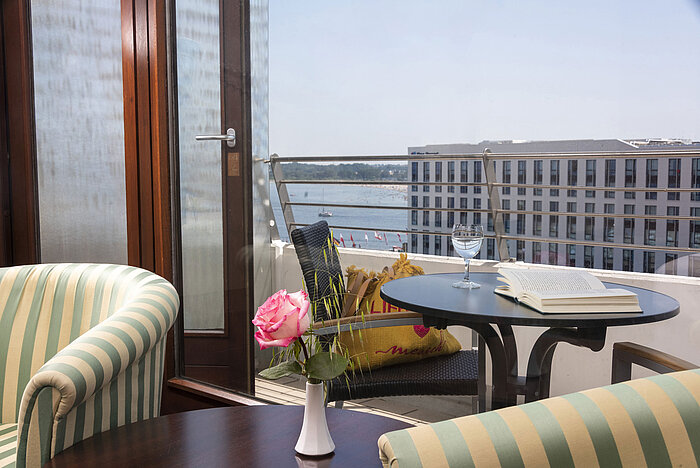 Gemütlicher Balkonplatz mit Buch, Rose und Blick auf das Wasser im Maritim Hotel Travemünde