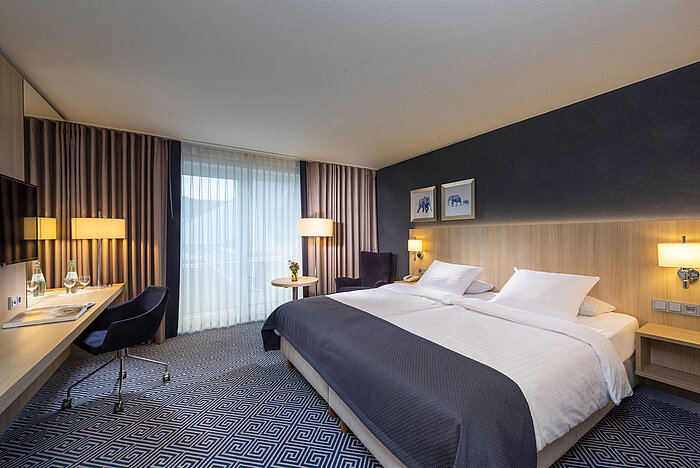 Großzügiges Comfort Zimmer im Maritim Hotel Würzburg mit Schreibtisch, Doppelbett und bodentiefen Fenstern