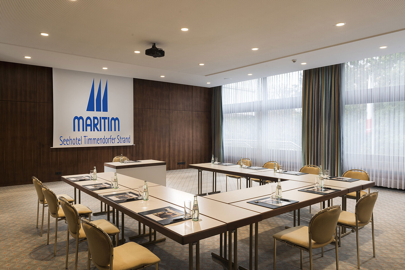 Konferenzraum „Salon Köln“ im Maritim Seehotel Timmendorfer Strand mit U-förmiger Bestuhlung und Tageslicht.