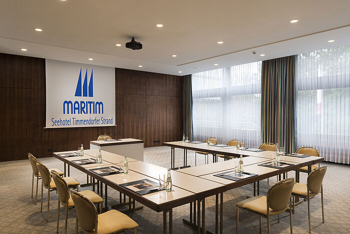 Konferenzraum „Salon Köln“ im Maritim Seehotel Timmendorfer Strand mit U-förmiger Bestuhlung und Tageslicht.