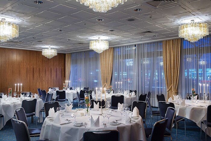 Stilvoll eingedeckter Veranstaltungsraum im Maritim Hotel Darmstadt mit runden Tischen, Kerzen und eleganter Atmosphäre.
