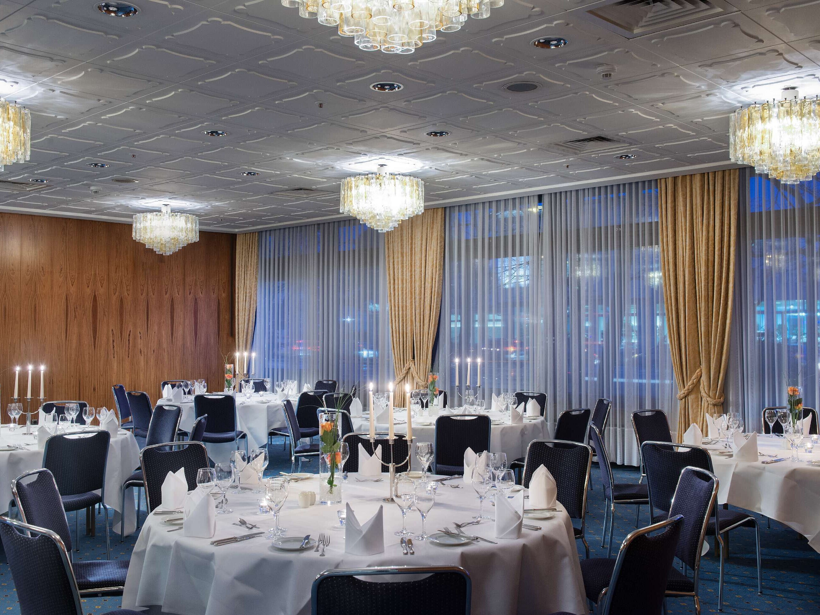 Stilvoll eingedeckter Veranstaltungsraum im Maritim Hotel Darmstadt mit runden Tischen, Kerzen und eleganter Atmosphäre.