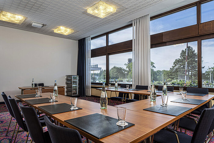 Konferenzraum mit großen Fenstern, Tageslicht und U-förmiger Bestuhlung im Maritim Hotel Travemünde