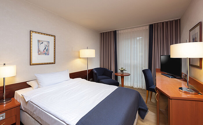 Klassisches Einzelzimmer im Maritim Hotel Würzburg mit gemütlichem Sessel und hellem Design